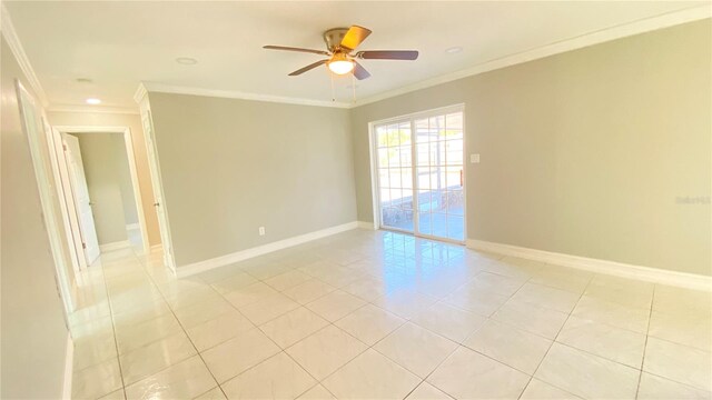 empty room featuring ceiling fan, light tile patterned flooring, and ornamental molding