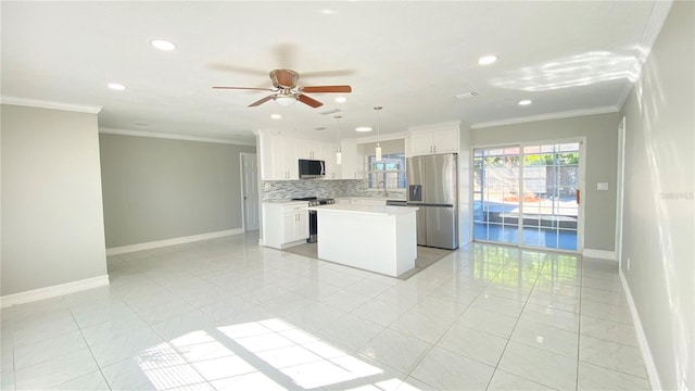 kitchen with tasteful backsplash, white cabinets, stainless steel appliances, and a kitchen island