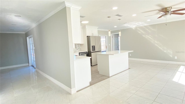 kitchen featuring appliances with stainless steel finishes, a kitchen island, crown molding, decorative light fixtures, and white cabinetry