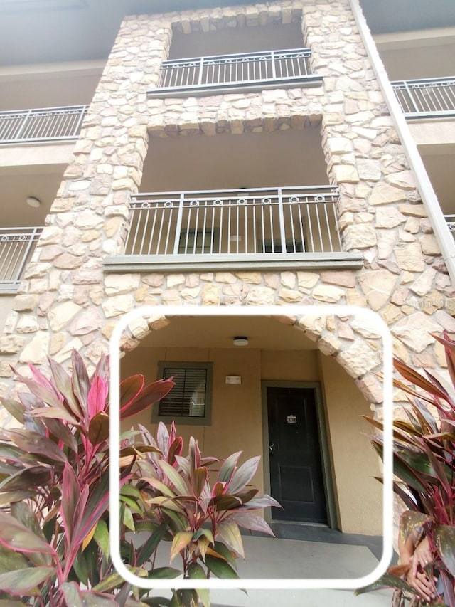 view of exterior entry featuring a balcony