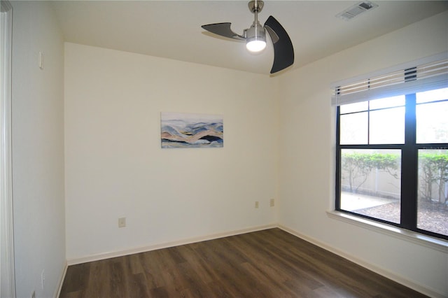 empty room with dark wood-type flooring, ceiling fan, and a healthy amount of sunlight