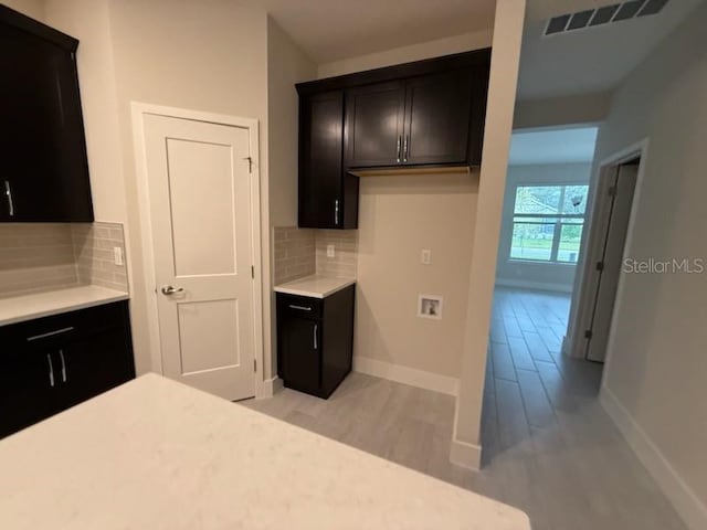 kitchen featuring light wood-type flooring and backsplash