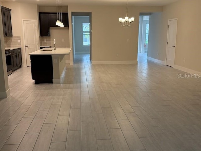 kitchen featuring backsplash, a chandelier, pendant lighting, and light hardwood / wood-style floors