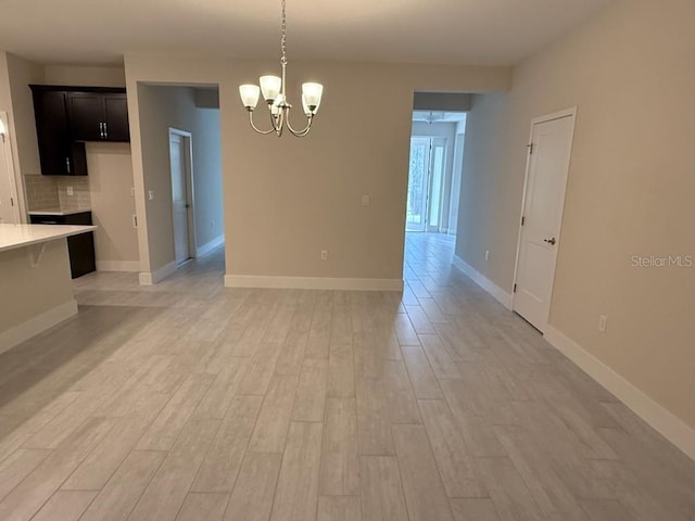 unfurnished dining area featuring light hardwood / wood-style floors and a notable chandelier