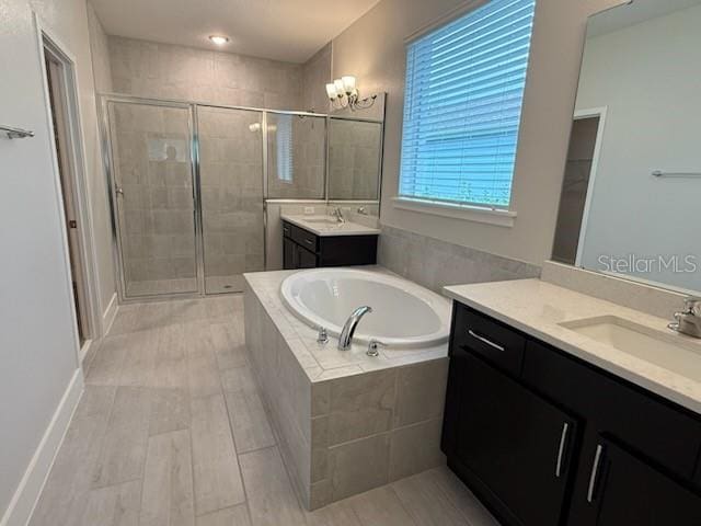 bathroom with plus walk in shower, vanity, and a notable chandelier