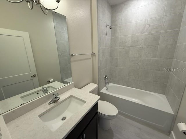 full bathroom featuring vanity, toilet, and tiled shower / bath