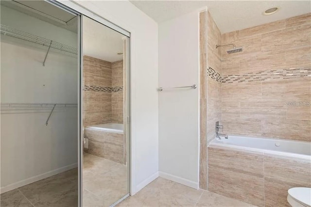 bathroom featuring tile patterned flooring, plus walk in shower, and toilet