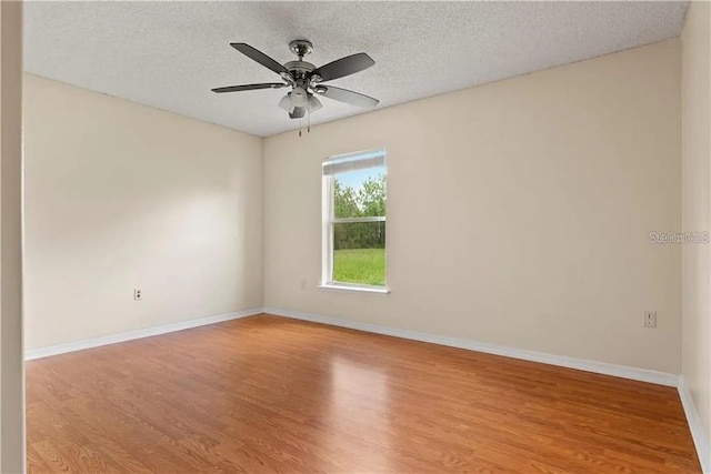 unfurnished room with a textured ceiling, light hardwood / wood-style floors, and ceiling fan