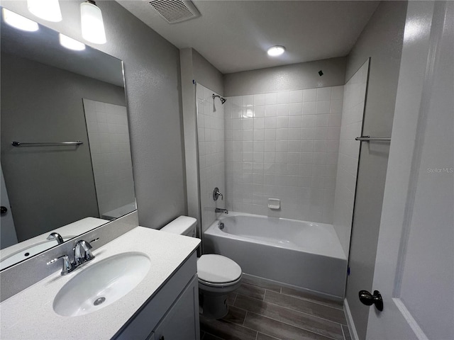 full bathroom with visible vents, toilet, shower / tub combination, wood tiled floor, and vanity