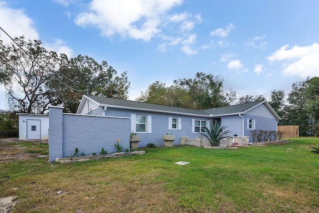 rear view of property featuring a lawn