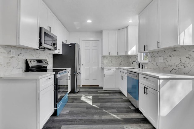 kitchen featuring decorative backsplash, dark hardwood / wood-style flooring, white cabinetry, and stainless steel appliances