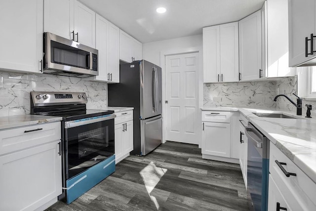 kitchen with white cabinets, sink, dark hardwood / wood-style floors, appliances with stainless steel finishes, and tasteful backsplash