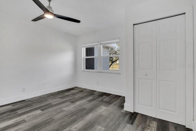 unfurnished bedroom with a closet, dark hardwood / wood-style floors, and ceiling fan