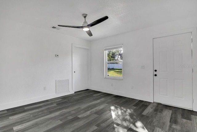 empty room featuring ceiling fan and dark hardwood / wood-style flooring