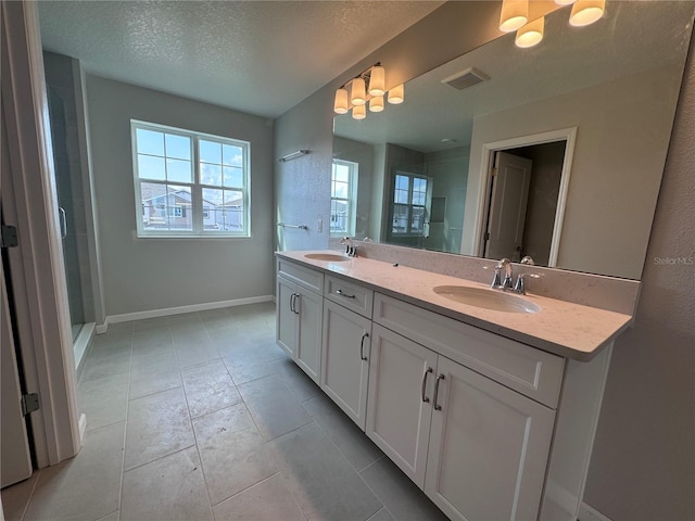 bathroom with vanity, tile patterned floors, a textured ceiling, and walk in shower