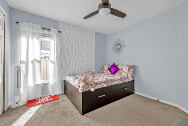 bedroom featuring ceiling fan, light colored carpet, and a textured ceiling