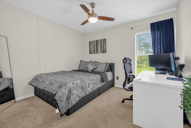 carpeted bedroom with ceiling fan and a textured ceiling