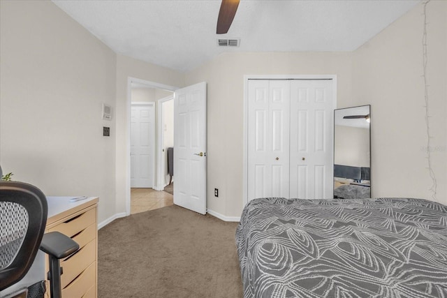 carpeted bedroom with a textured ceiling, a closet, and ceiling fan