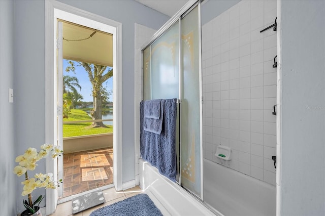 bathroom featuring tile patterned flooring, a water view, and bath / shower combo with glass door