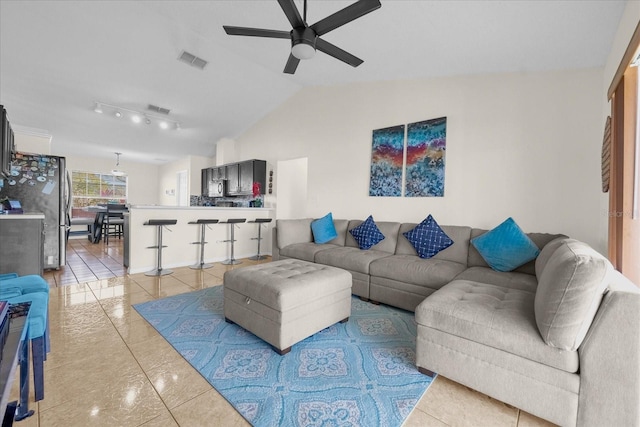 living room featuring ceiling fan, light tile patterned floors, and lofted ceiling