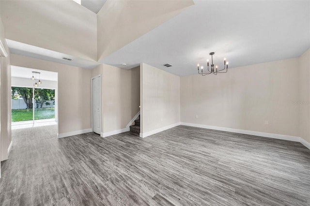 empty room featuring hardwood / wood-style flooring and a notable chandelier