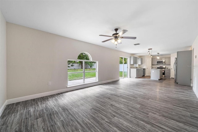 unfurnished living room featuring dark hardwood / wood-style floors and ceiling fan