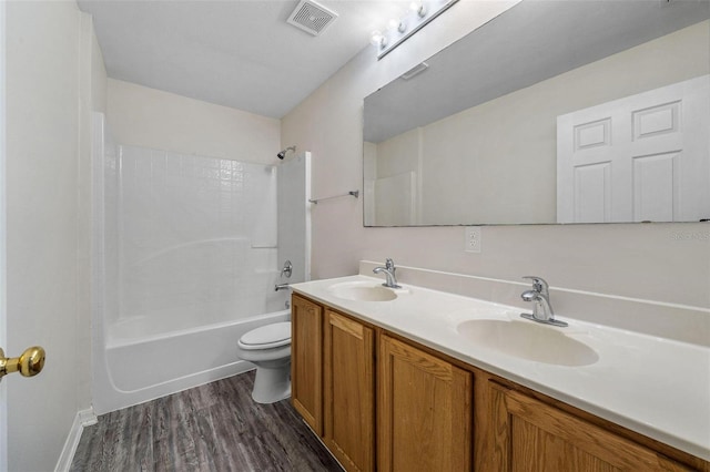 full bathroom with bathtub / shower combination, wood-type flooring, vanity, and toilet