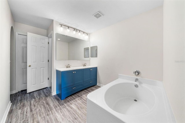 bathroom featuring a tub, vanity, and wood-type flooring