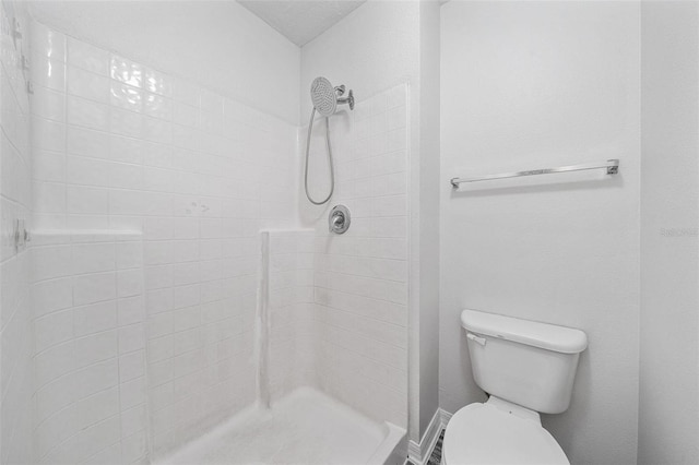 bathroom with toilet and a tile shower