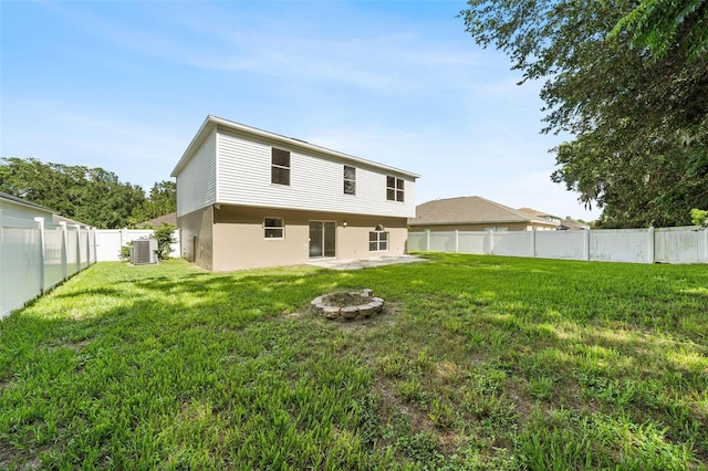 back of house with central air condition unit and a yard