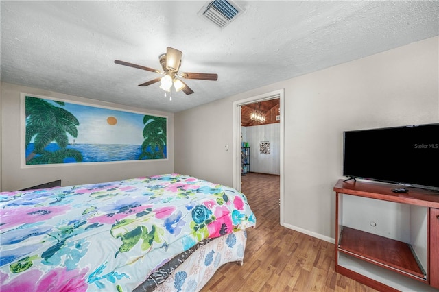 bedroom featuring a textured ceiling, light hardwood / wood-style flooring, and ceiling fan