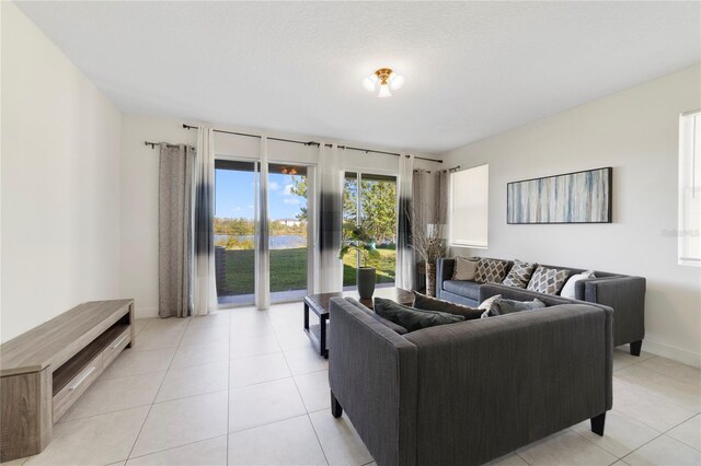 470 Lake Shore Pkwy, Davenport, FL 33896 - living area with light tile patterned floors, baseboards, and a water view