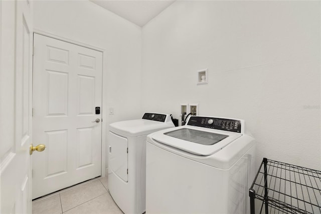 laundry area with light tile patterned floors and washer and dryer