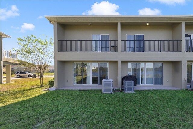 470 Lake Shore Pkwy, Davenport, FL 33896 - back of property featuring stucco siding, central AC unit, a yard, and a balcony
