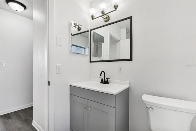 bathroom featuring wood-type flooring, vanity, and toilet