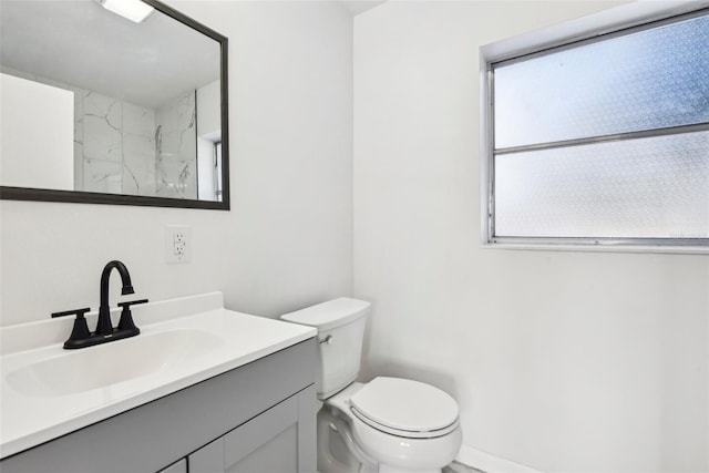 bathroom featuring walk in shower, vanity, and toilet