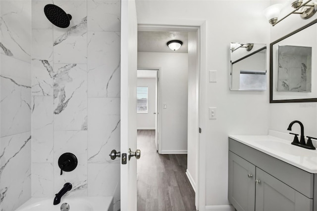 bathroom with tiled shower / bath combo, wood-type flooring, and vanity