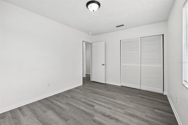 unfurnished bedroom featuring a closet and dark hardwood / wood-style floors