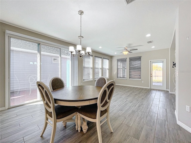 dining area with visible vents, baseboards, recessed lighting, ceiling fan with notable chandelier, and wood finished floors