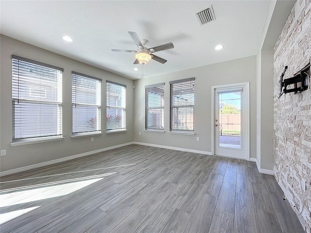 unfurnished room with ceiling fan, wood-type flooring, and a textured ceiling