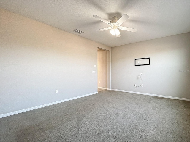 carpeted empty room with ceiling fan and a textured ceiling