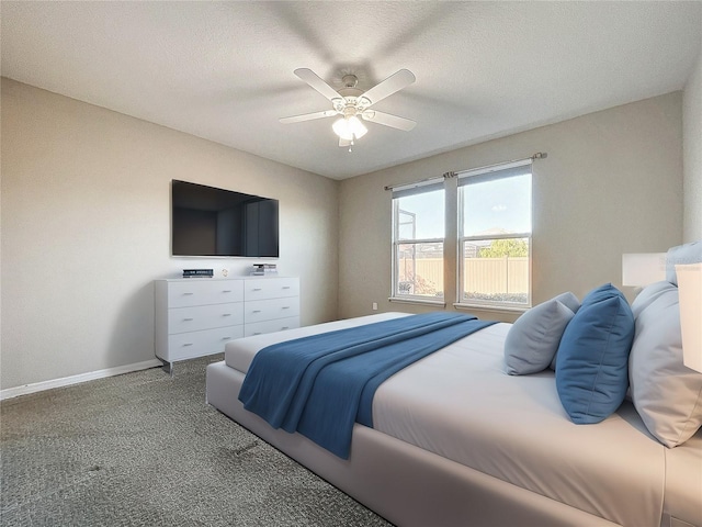 carpeted bedroom with a textured ceiling, baseboards, and a ceiling fan