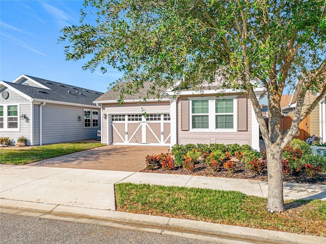 view of front of house with decorative driveway and a garage