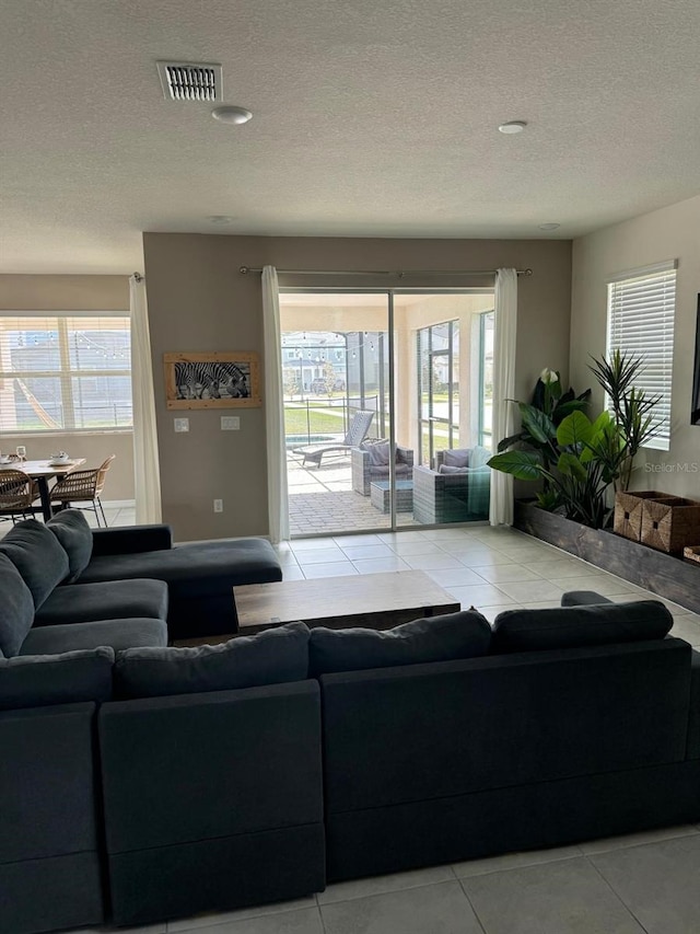 living room with light tile patterned flooring and a textured ceiling