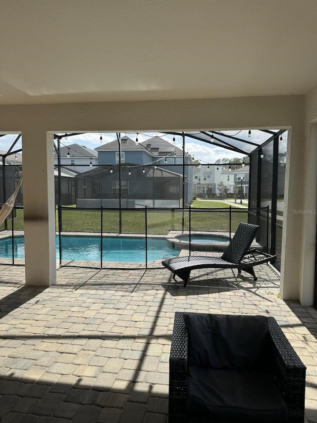 view of swimming pool with a patio area, a lanai, and an in ground hot tub