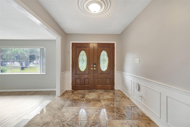 entrance foyer featuring a textured ceiling and french doors