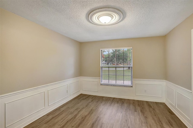 empty room featuring hardwood / wood-style floors and a textured ceiling