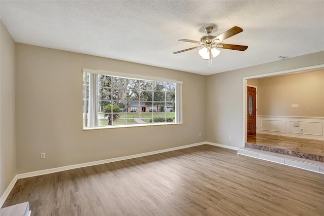 spare room featuring hardwood / wood-style floors, ceiling fan, and a textured ceiling