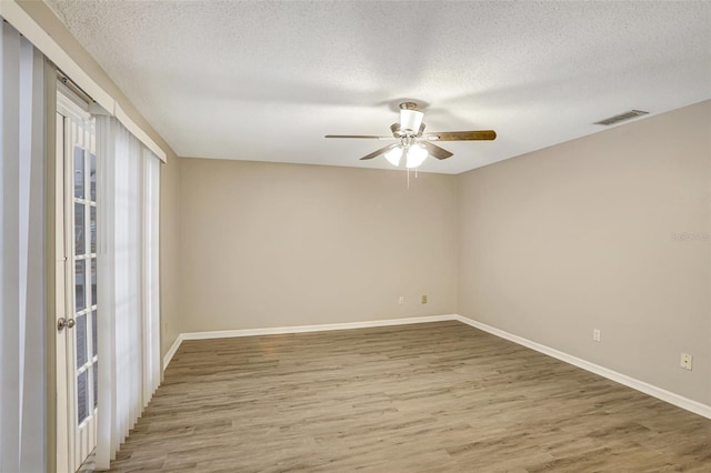 empty room featuring hardwood / wood-style floors, ceiling fan, and a textured ceiling