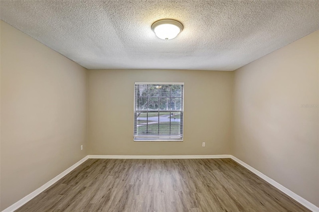 unfurnished room featuring a textured ceiling and hardwood / wood-style flooring